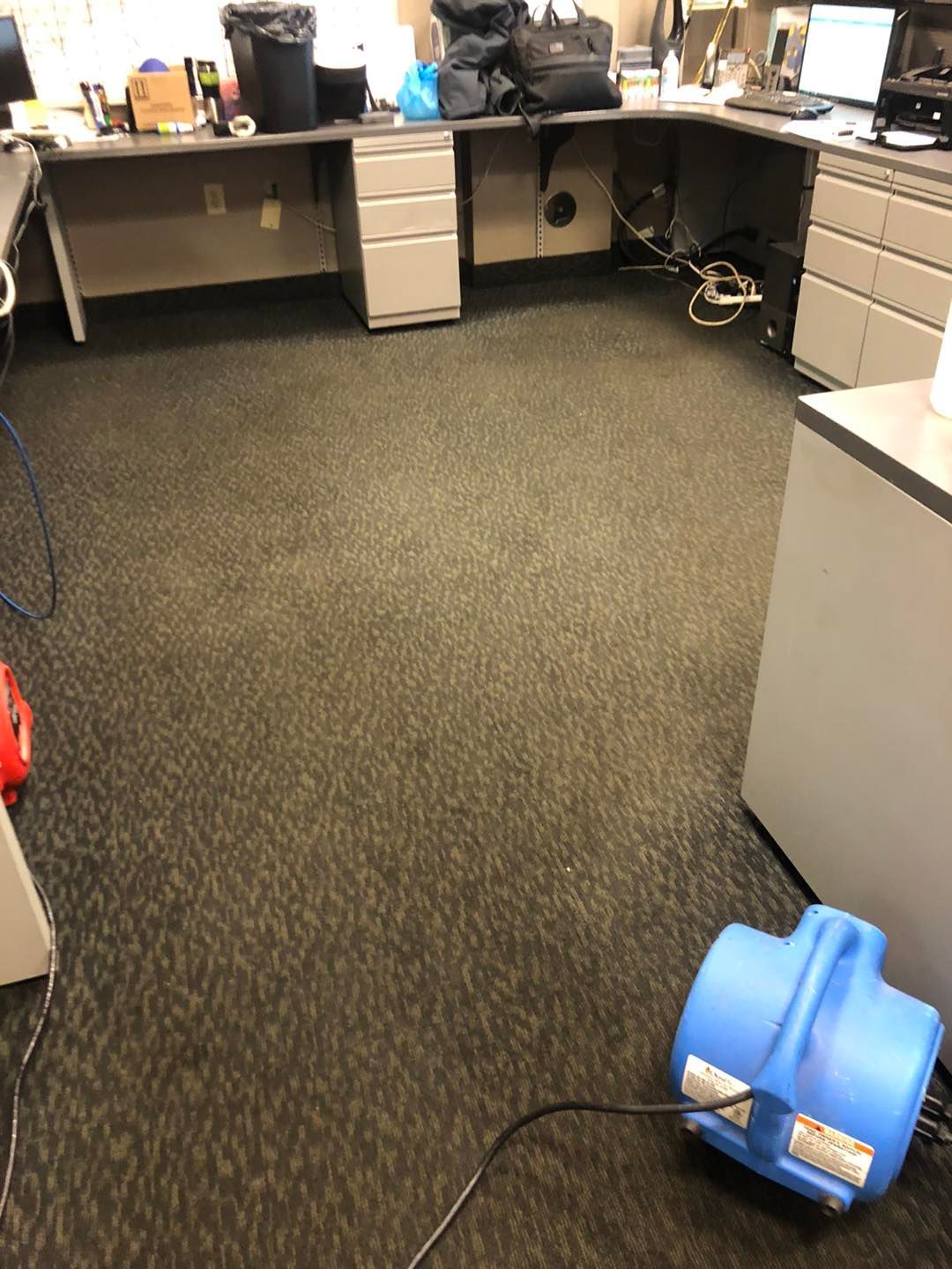 Office floor with a blue vacuum cleaner positioned on it in a Cleveland‑area workplace.