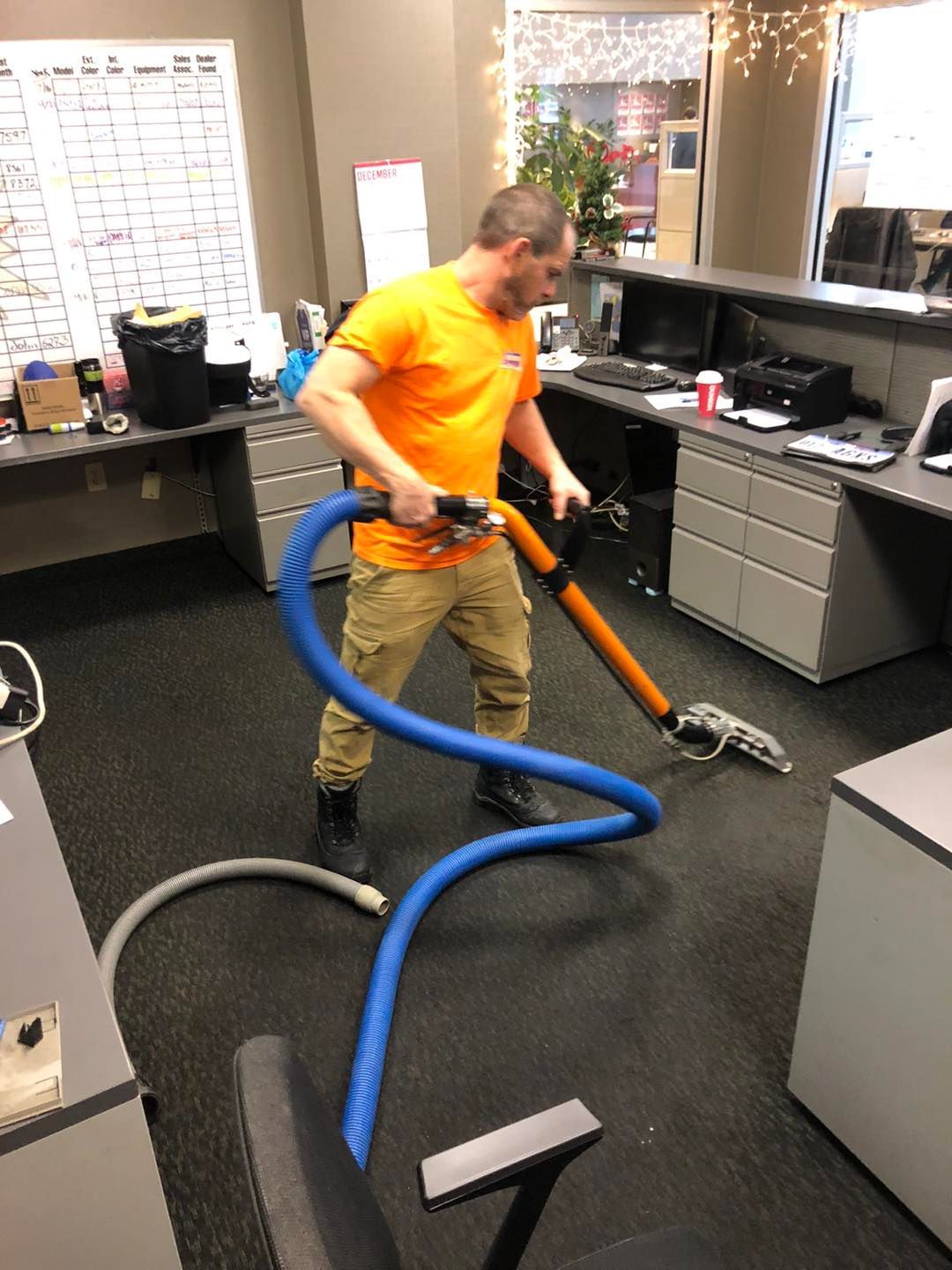 Office floor being cleaned with a vacuum cleaner by a man in a Cleveland‑area workplace.