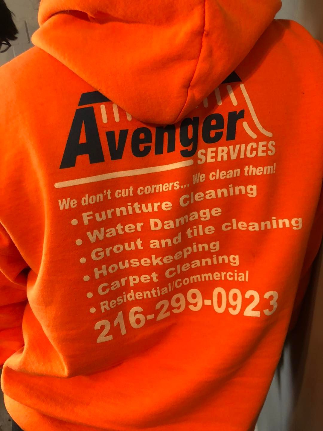 Individual in an orange ‘Avenger Services’ hoodie inside a Cleveland‑area property.