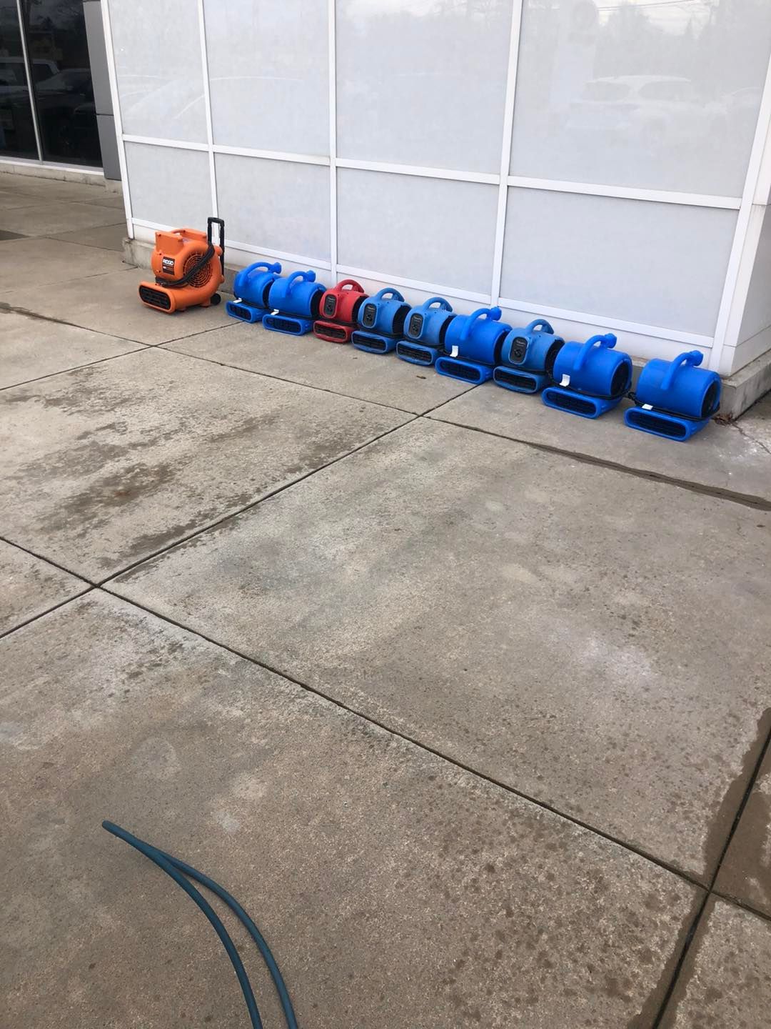 Professional drying equipment in blue and orange lined up on a sidewalk in Cleveland.