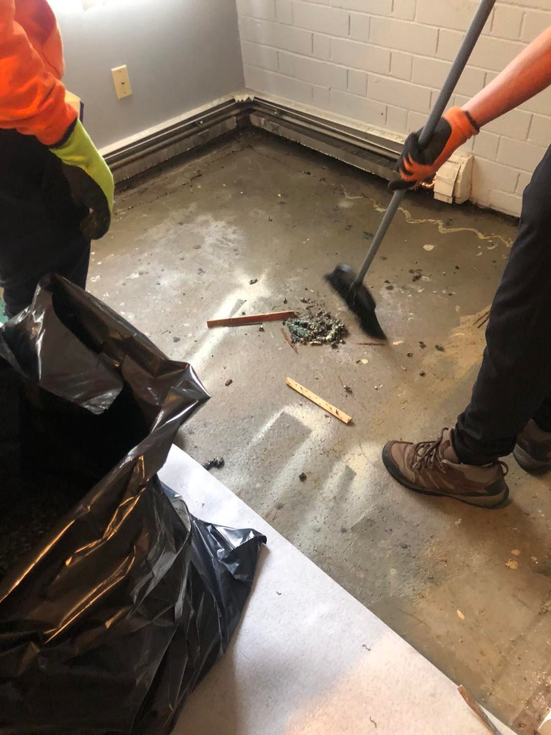 Person sweeping and cleaning a dirty floor near me in Cleveland, OH