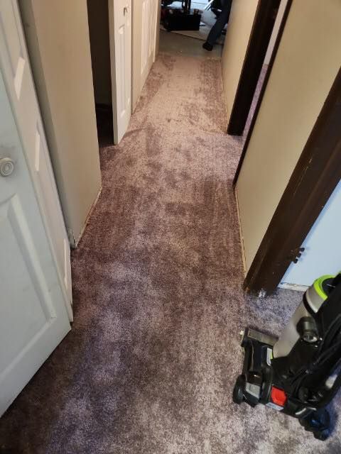 Vacuum cleaner sitting on the floor in a hallway next to a door in a Cleveland home.