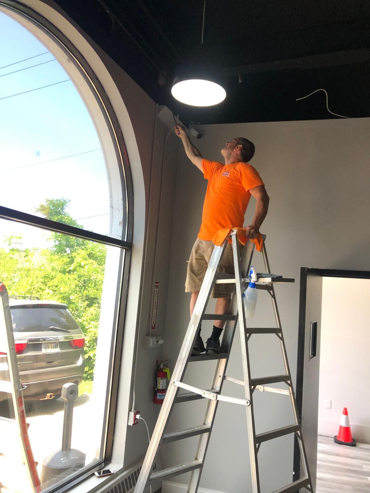 Man standing on a ladder in front of a fire extinguisher