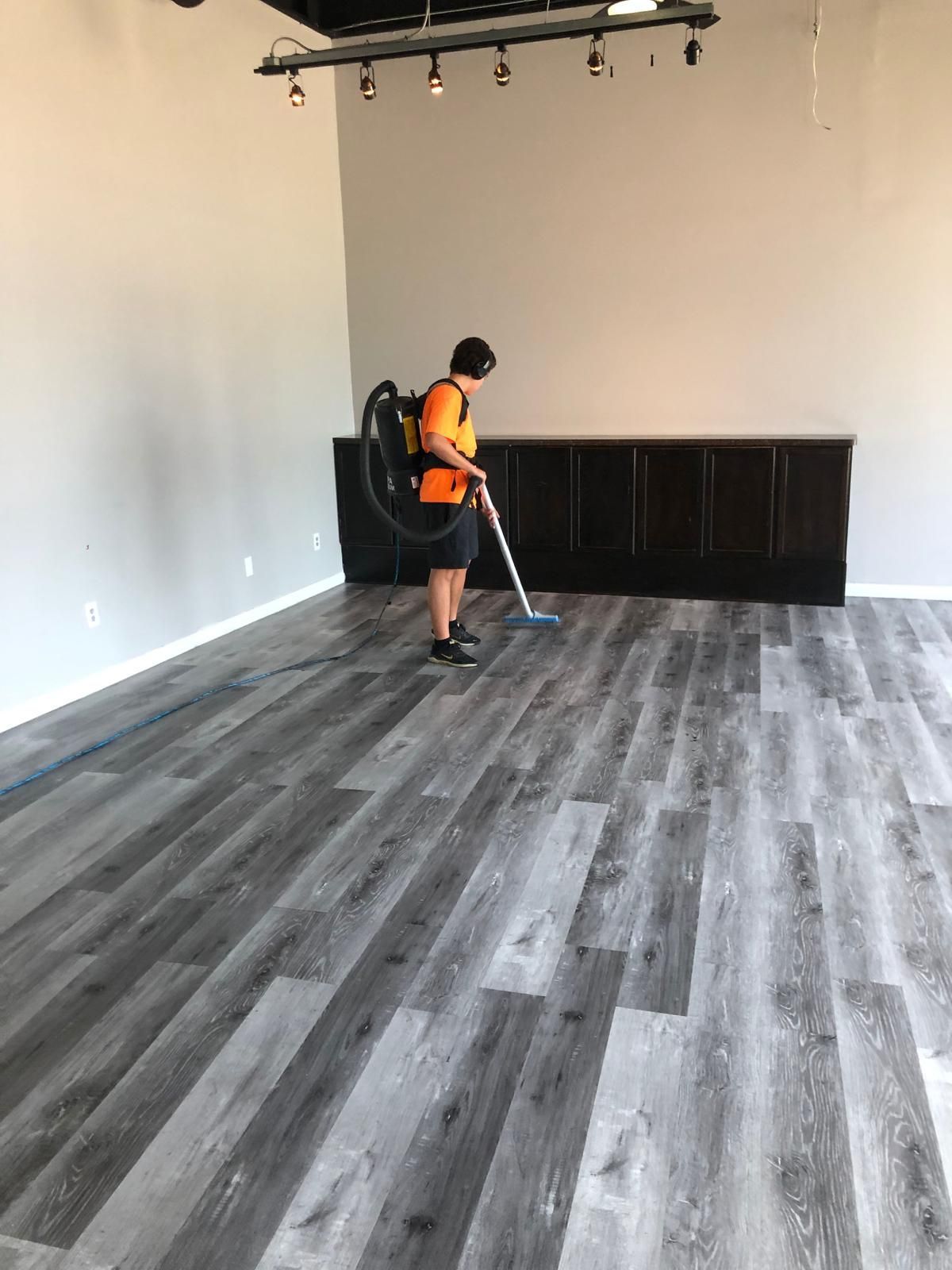 Man using a vacuum cleaner to clean a wooden floor near me in Cleveland, OH