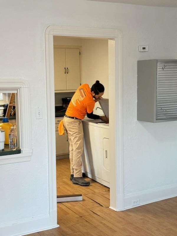 Man in orange shirt performing appliance cleaning near me in Cleveland, OH.