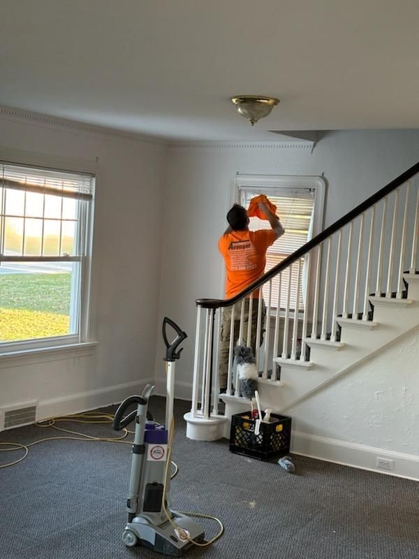 Man in orange shirt standing next to a staircase