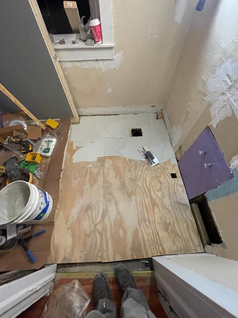 a bucket of white paint sits on a wooden floor