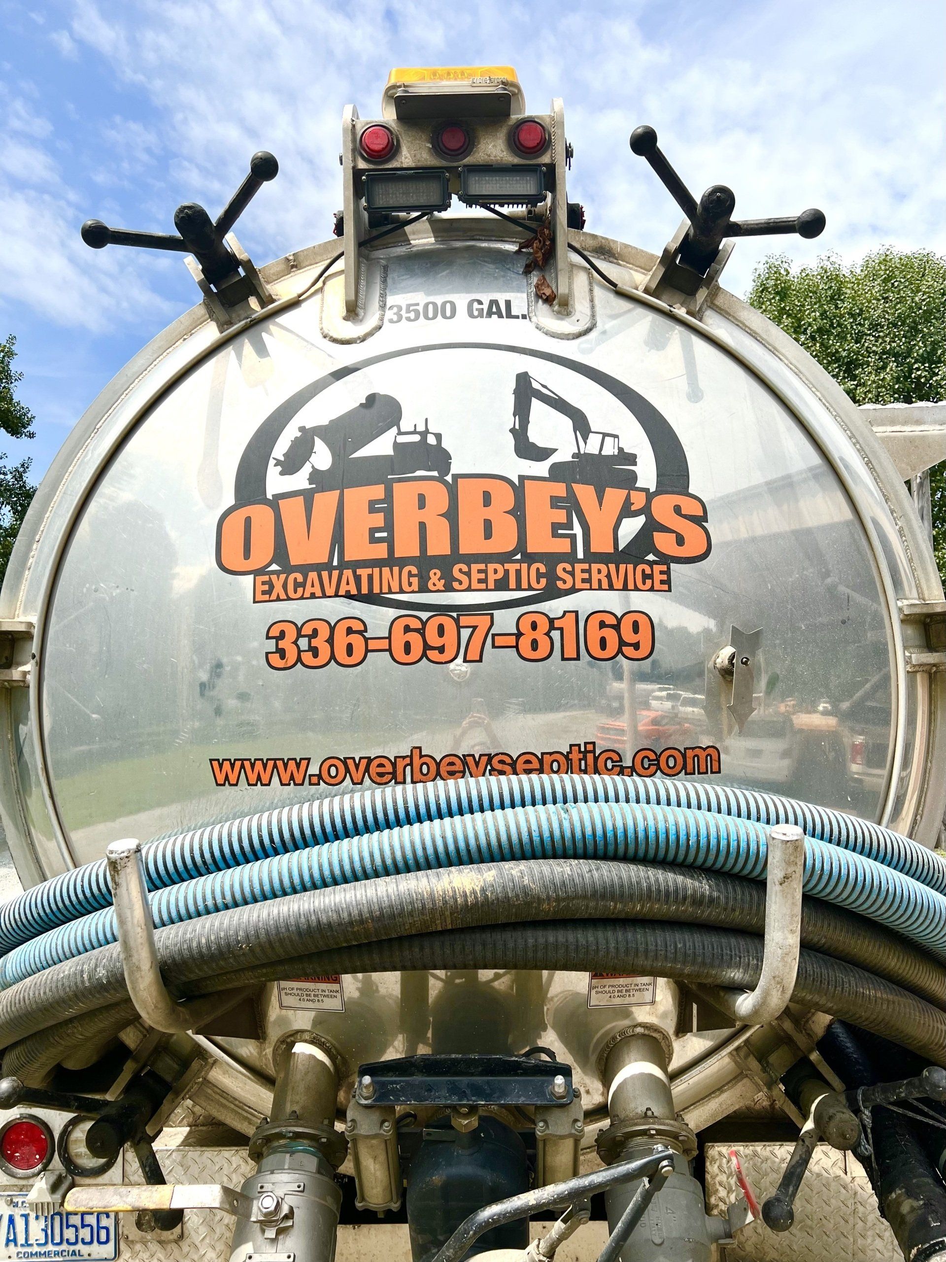 Rear view of Overbey's Septic Service truck with logo and contact info.