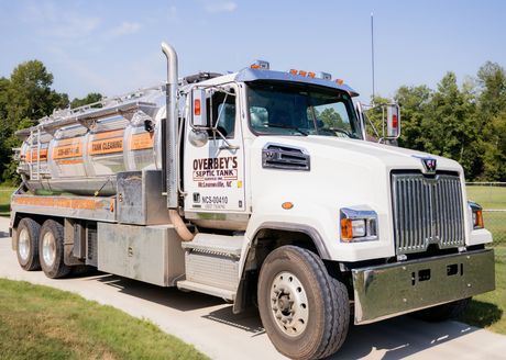 A white Western Star tanker truck parked on a grassy verge, showing a large chrome tank and metallic equipment.