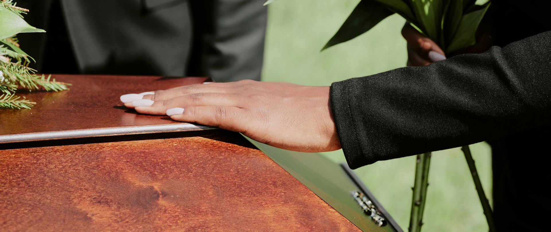 Hand resting on a brown-speckled tabletop beside a green wall and a small cup.