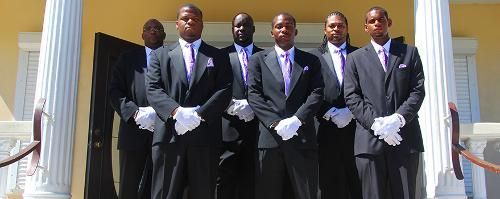 Five men in dark suits and ties stand on courthouse steps, posing together.