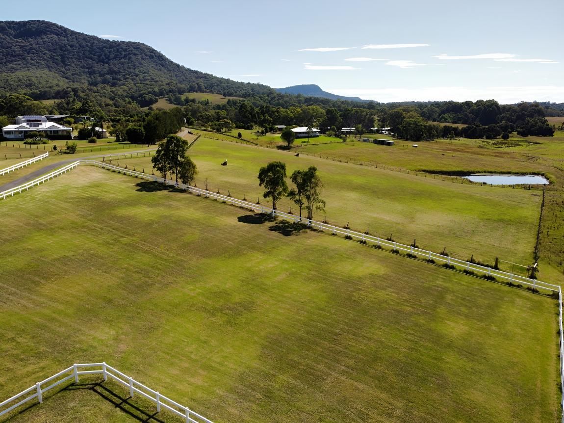 Grassy Field With A White Fence And Mountains In The Background — The Local Bloke Lawn & Garden Care In Warners Bay, NSW
