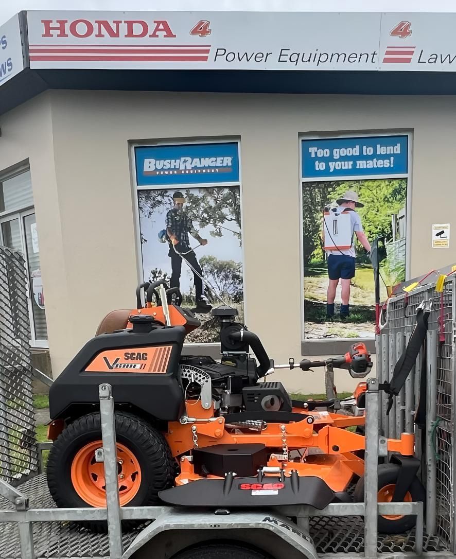 A Lawn Mower Is Parked In Front Of A Honda Store — The Local Bloke Lawn & Garden Care In Warners Bay, NSW