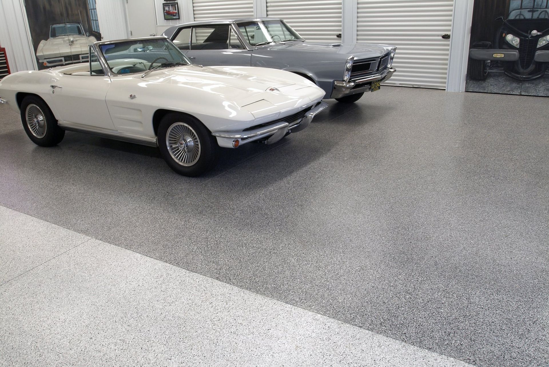 Classic white convertible and dark vintage car parked in a polished showroom