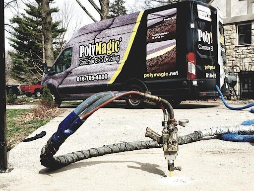 A van with a hose attached to it is parked in a driveway.