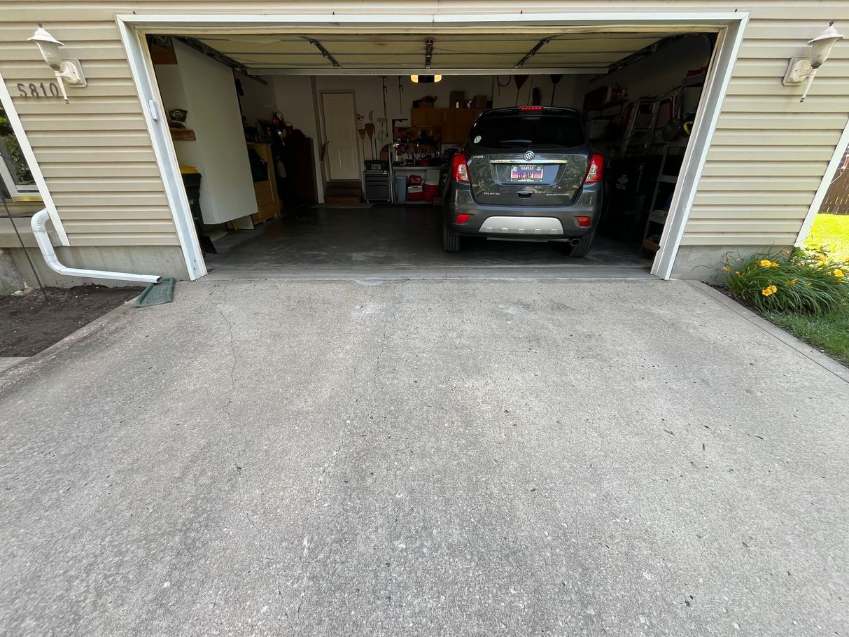 A car is parked in a garage with the door open.