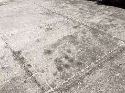 A close up of a concrete floor with a lot of spots on it.
