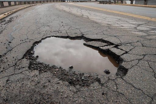 A large pothole in the middle of a road