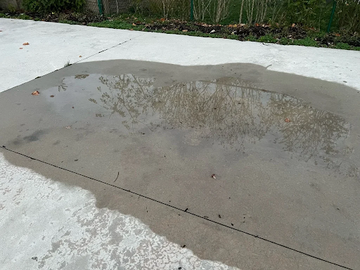 A puddle of water on a concrete surface