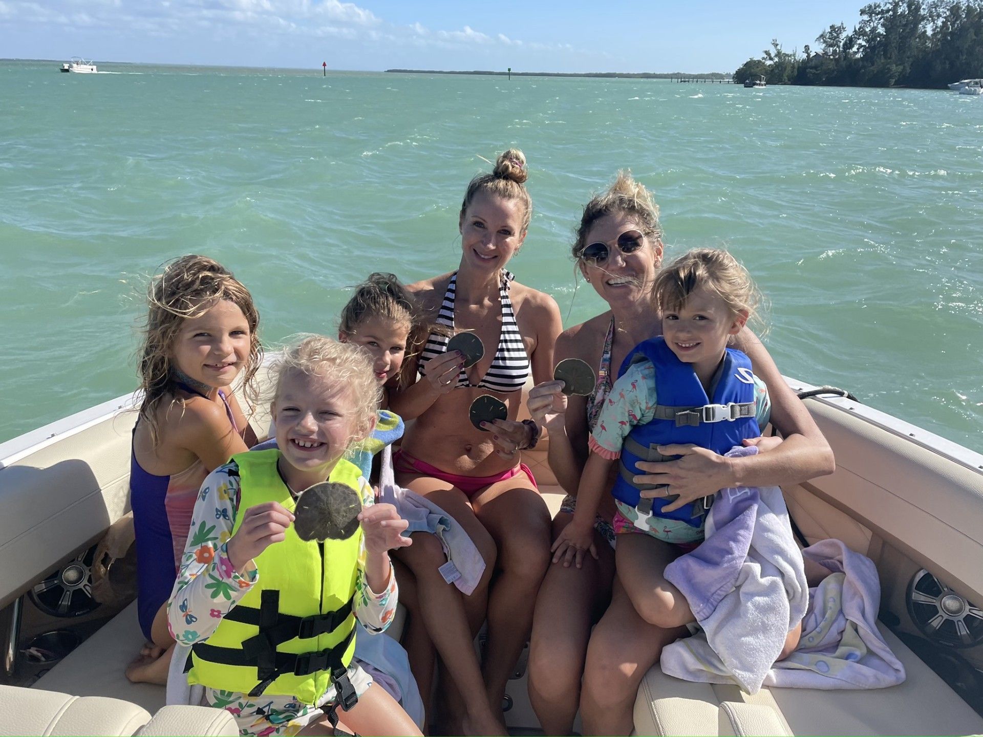 a family on their day trip to Anna Maria Island, sitting on a boat smiling 