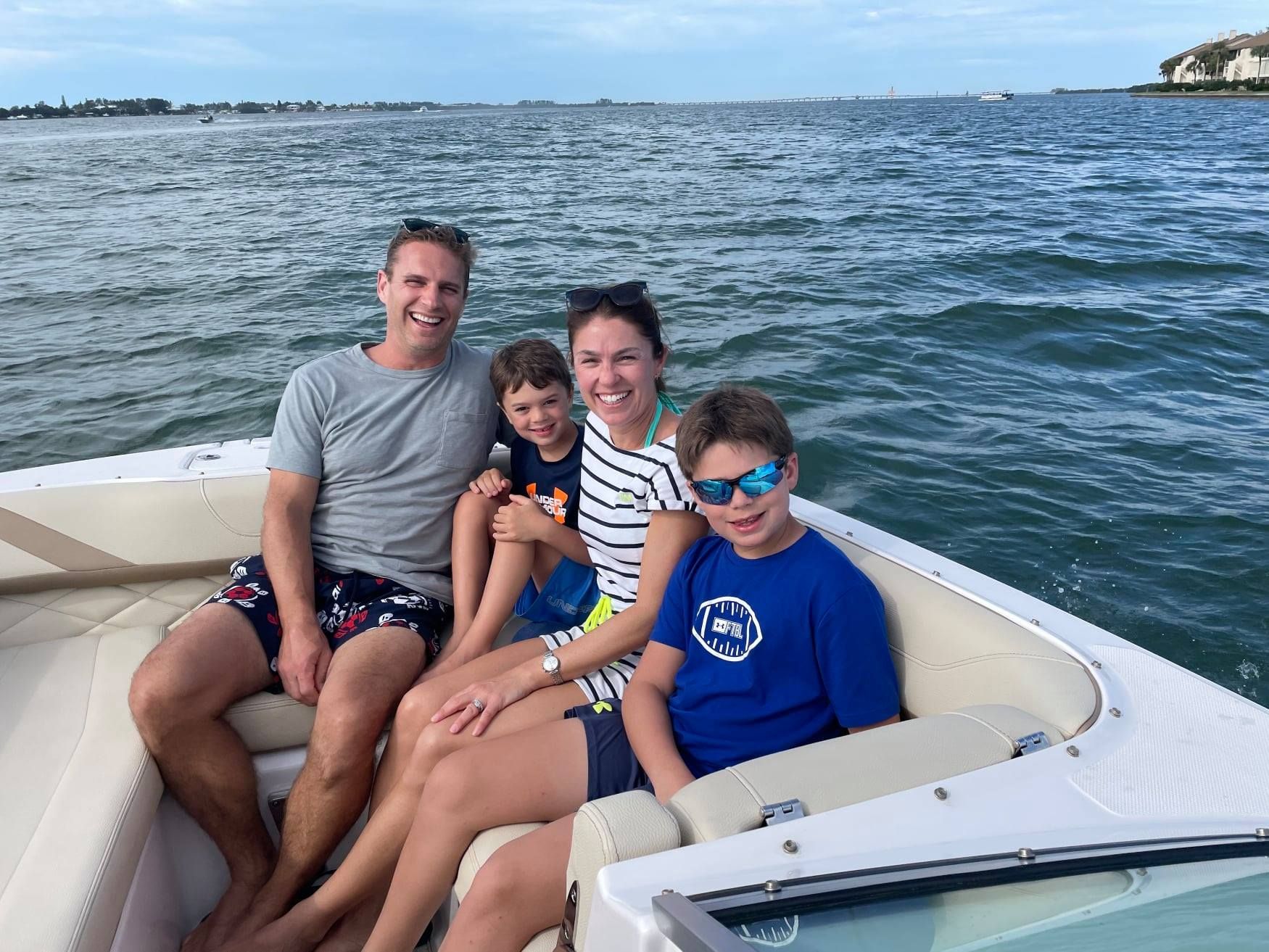 A family is sitting on a boat in the water.