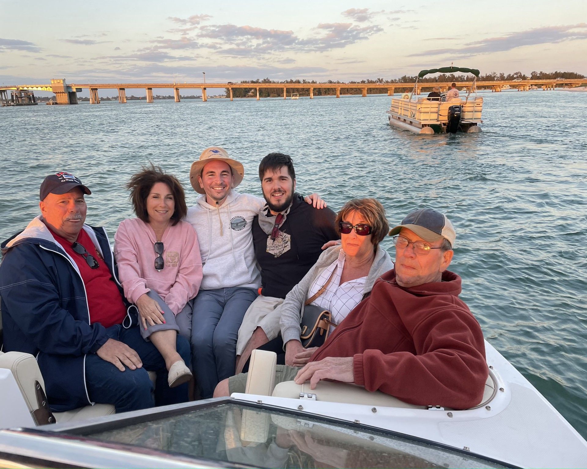 People in the back of a boat at sunset