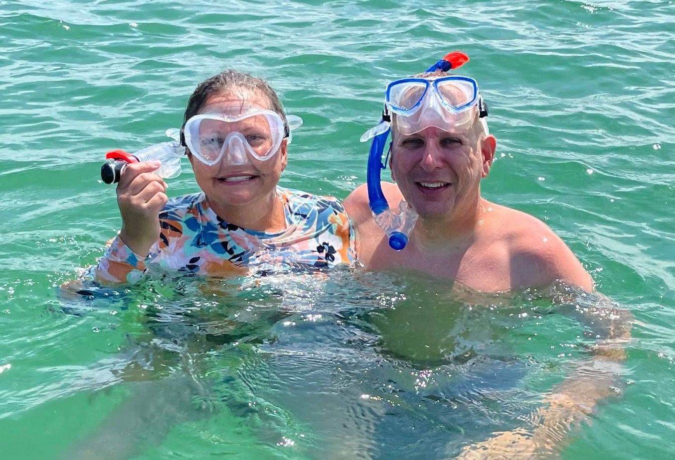 Two couples are snorkeling on the ocean
