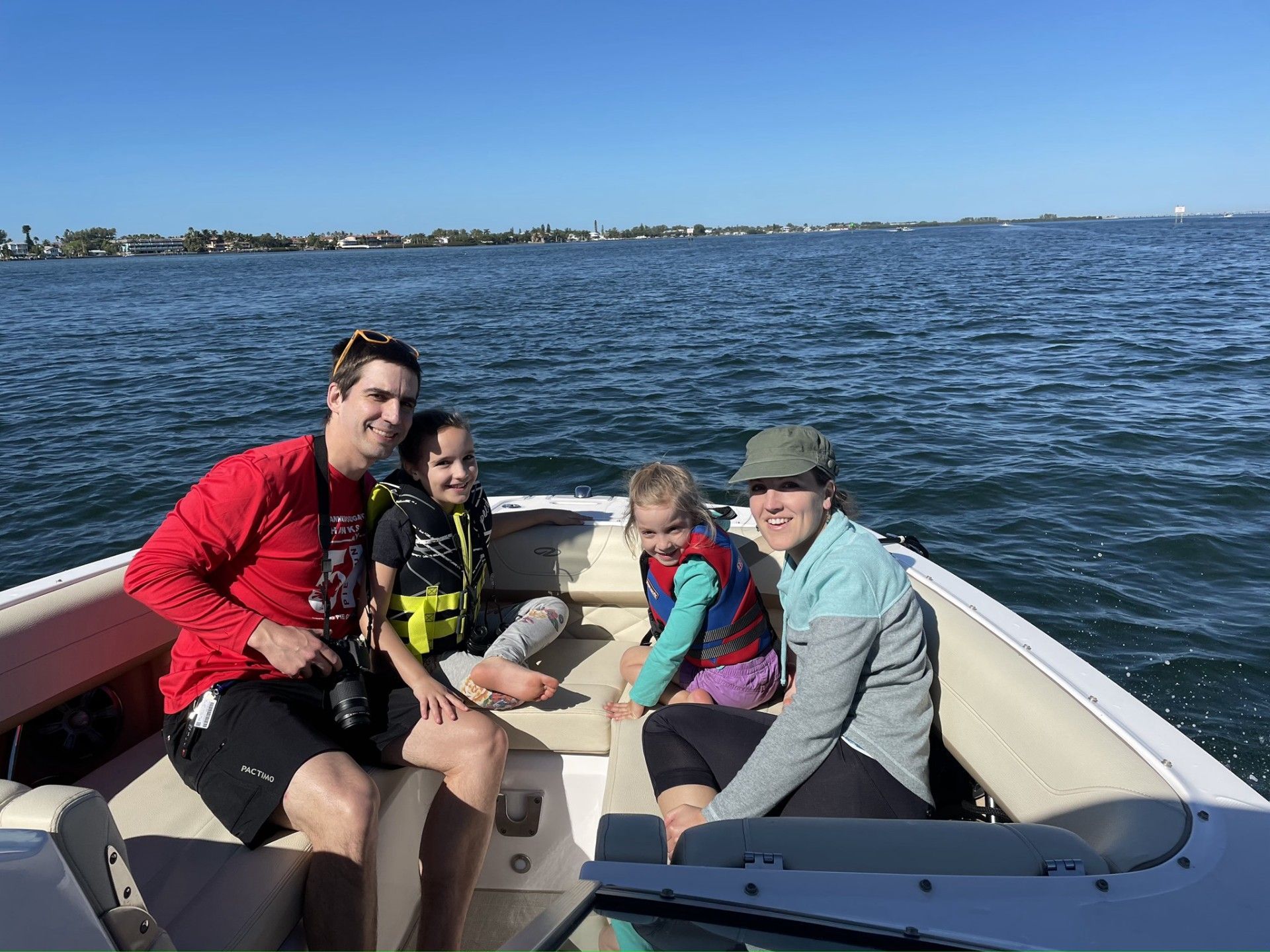 A family smiling in the back of a boat