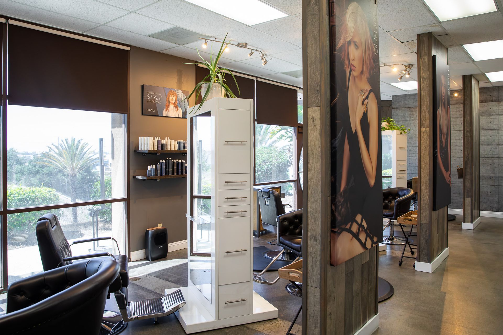Hair salon interior with styling stations, windows, and product displays.