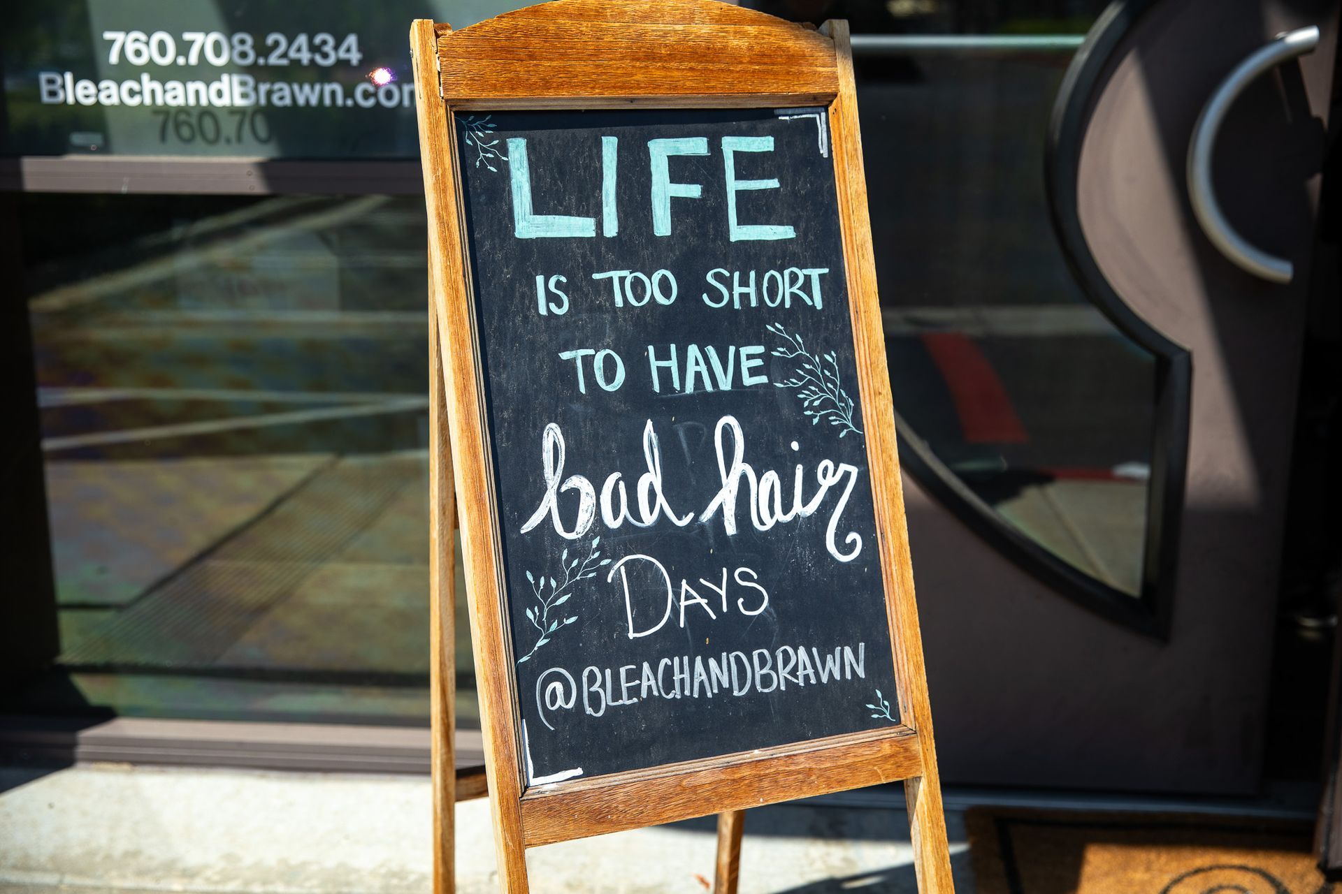 A-frame chalkboard sign outside a salon: