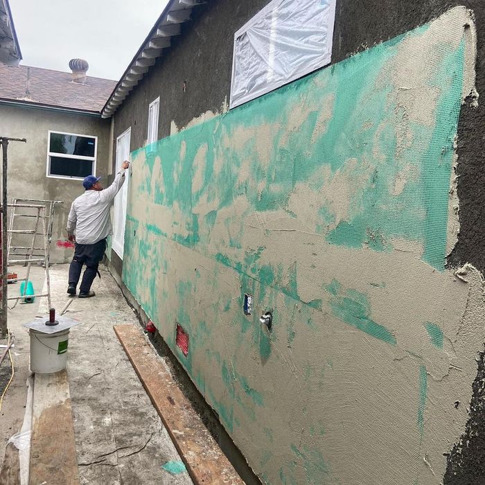 Man preparing the siding for plastering