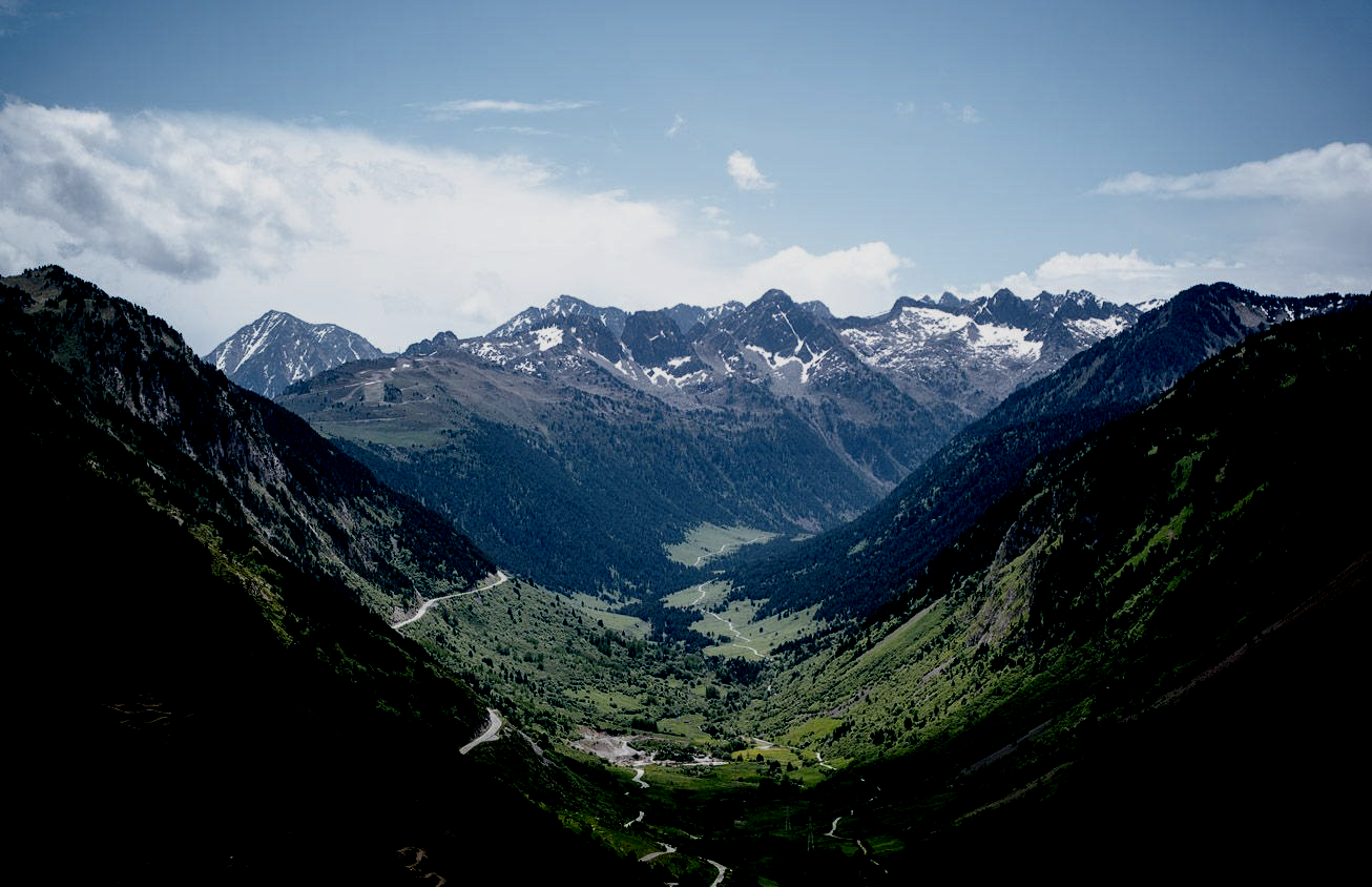 Valle de montaña con praderas verdes y un río