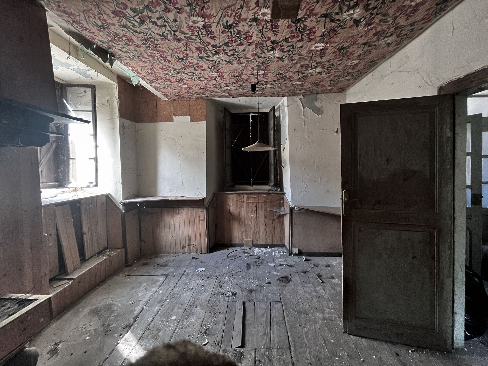 Estancia antigua con techo decorado antes de la rehabilitación