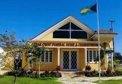 Yellow funeral home with Bahamian flag.