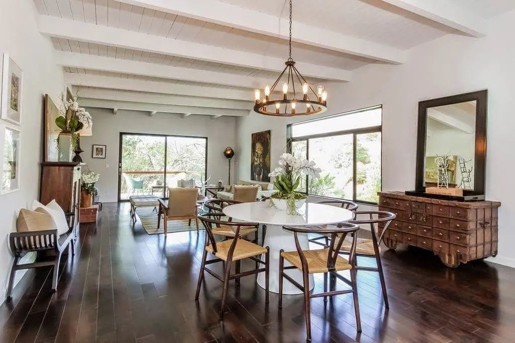 A large living room with a table and chairs and a mirror