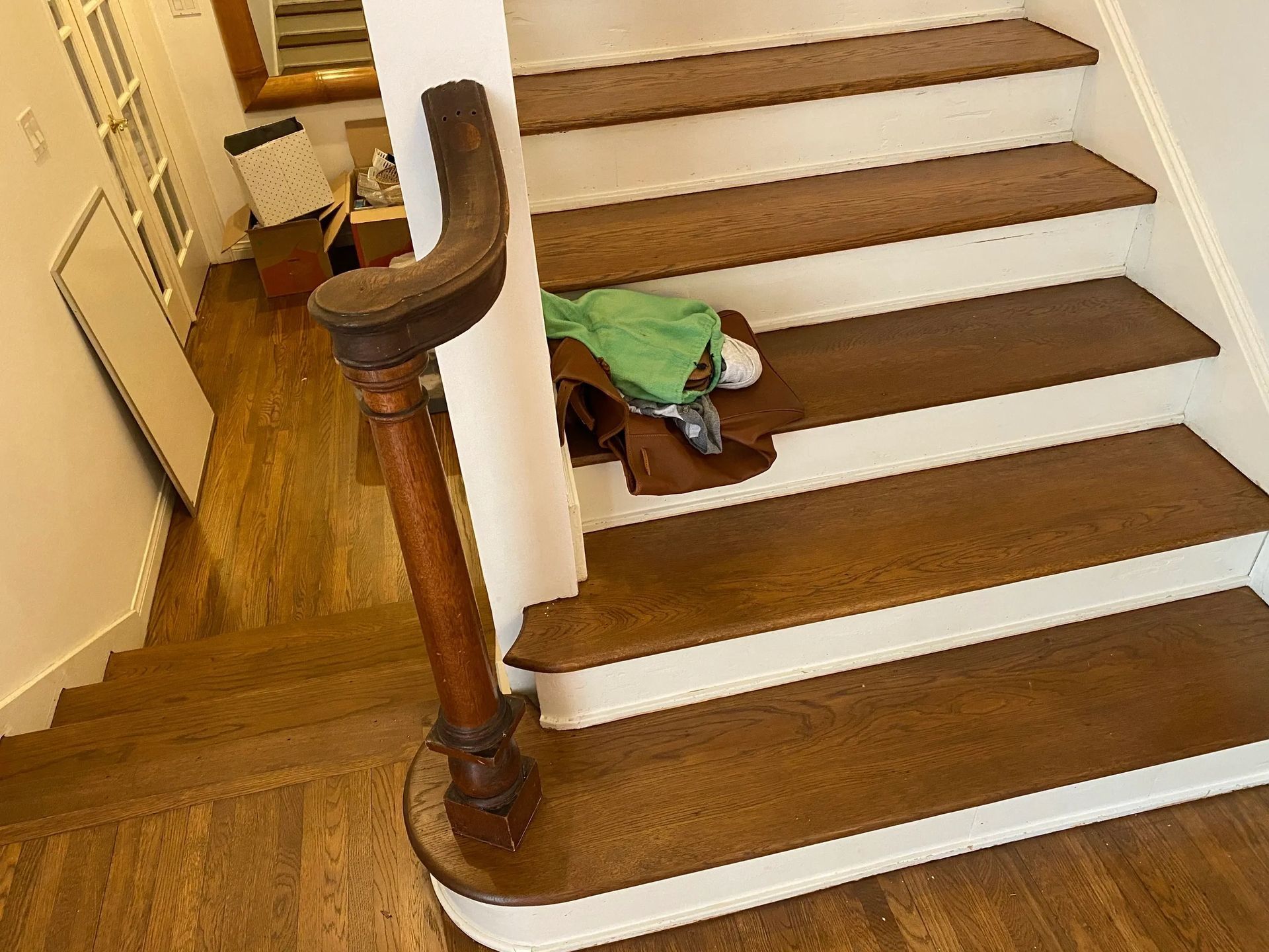 A wooden staircase with white steps and a wooden railing