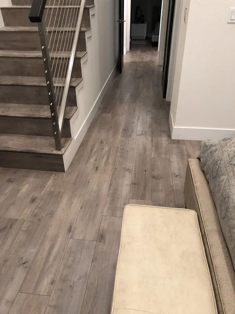 A hallway with wooden floors and stairs in a house