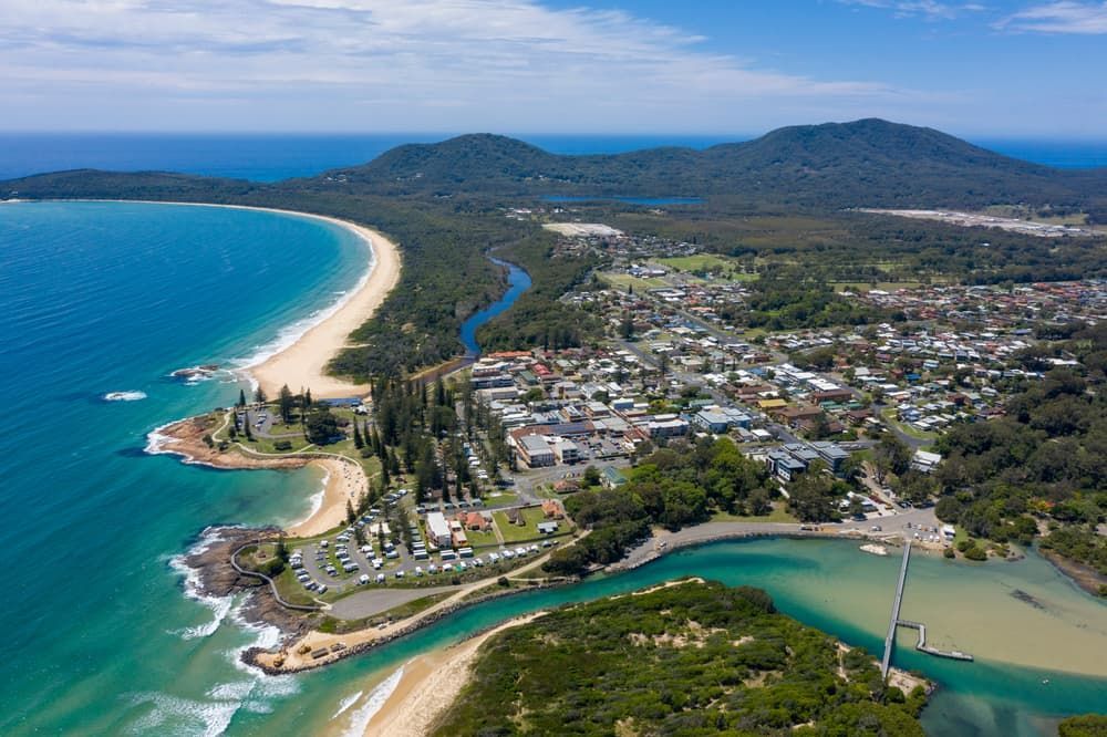 Aerial View of A Coastal Town with A Long Sandy Beach — Sew Affordable In Budgewoi, NSW