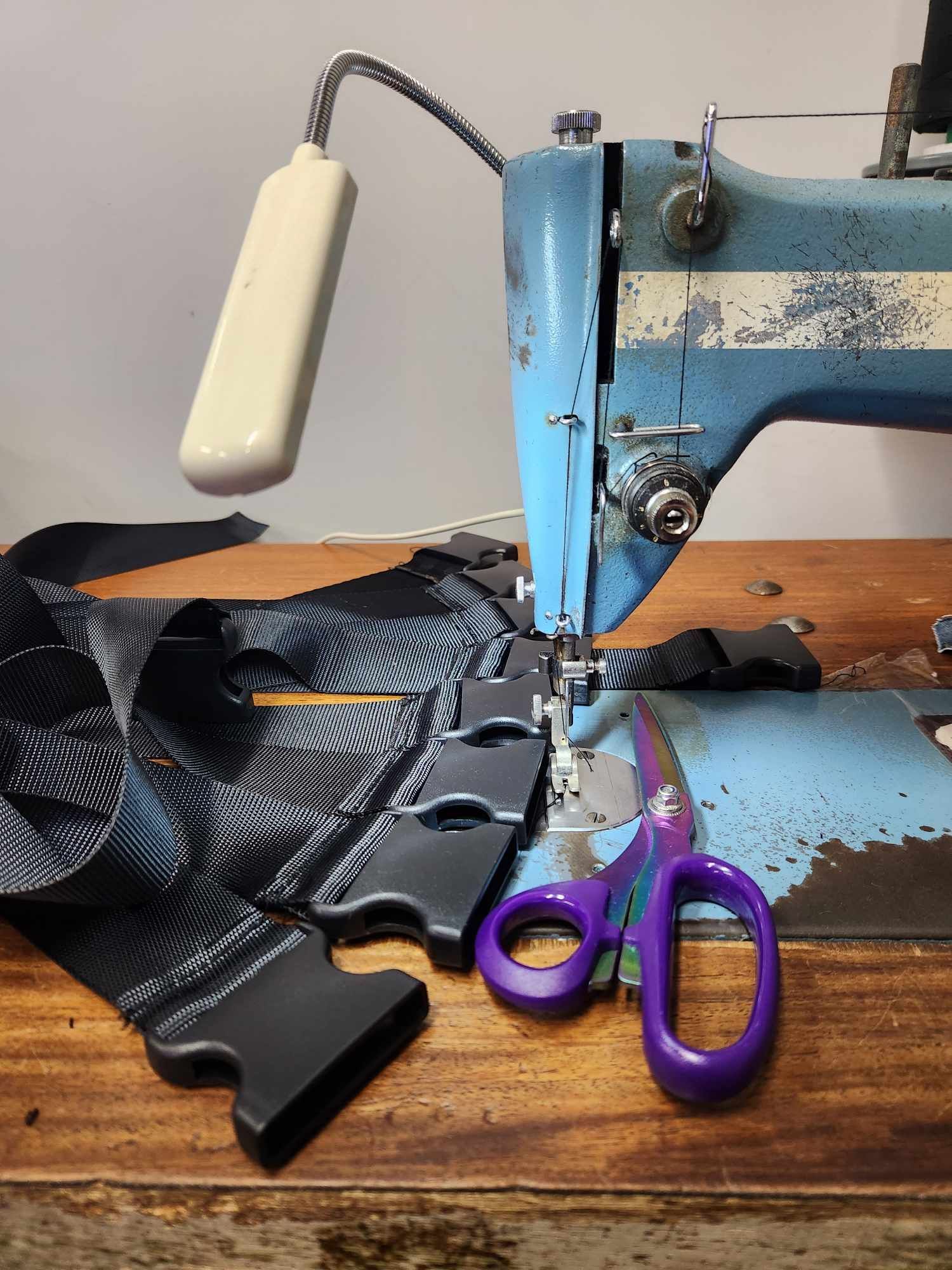 A Sewing Machine Is Sewing Buckles On Black Straps — Sew Affordable In Charmhaven, NSW