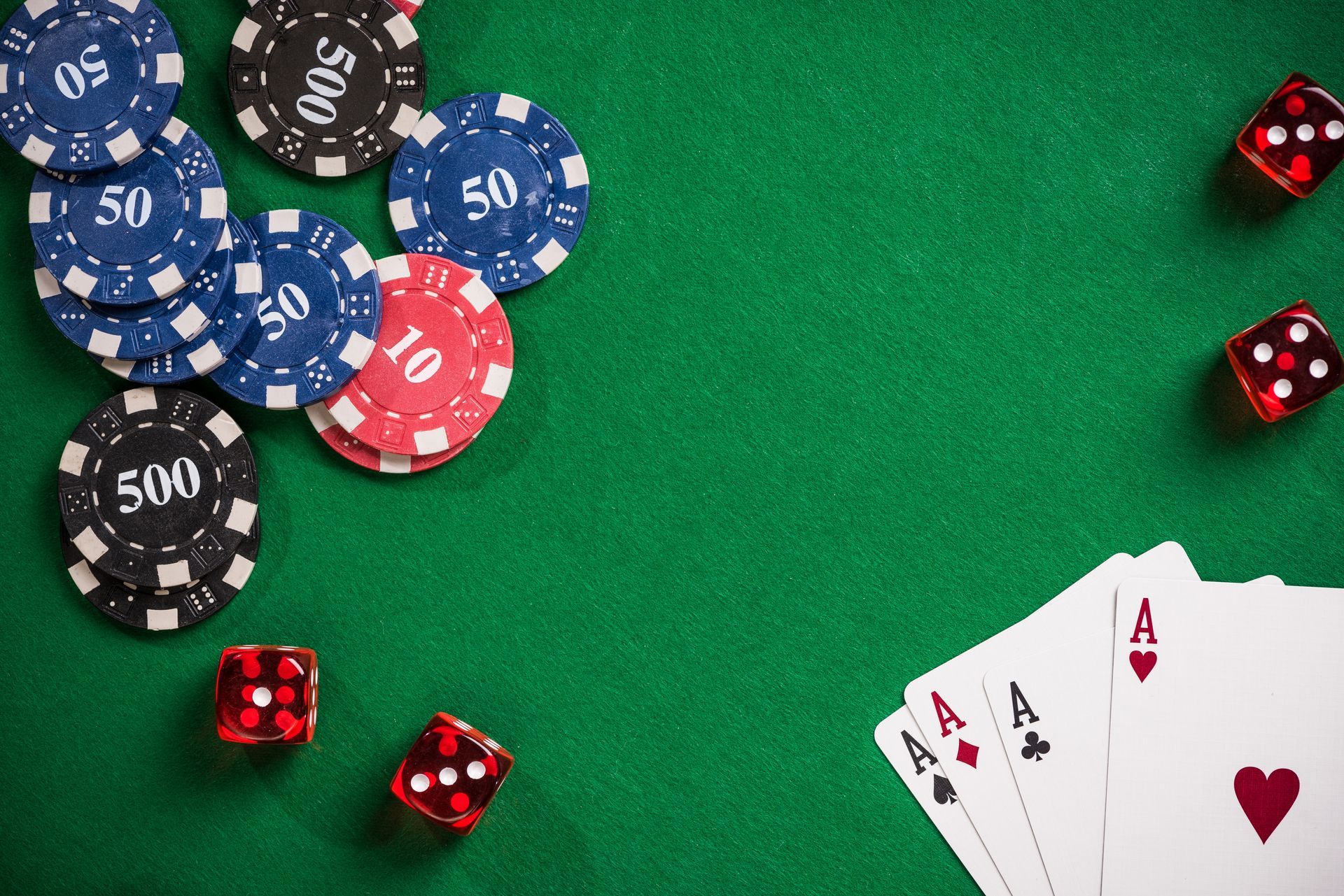 A poker table with chips , dice , and playing cards on it.
