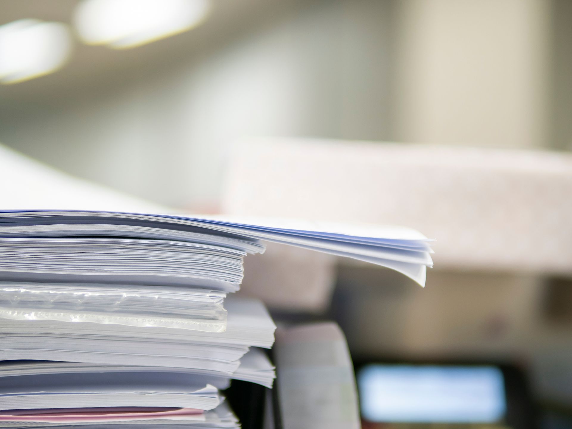 A close up of a stack of papers on a desk.