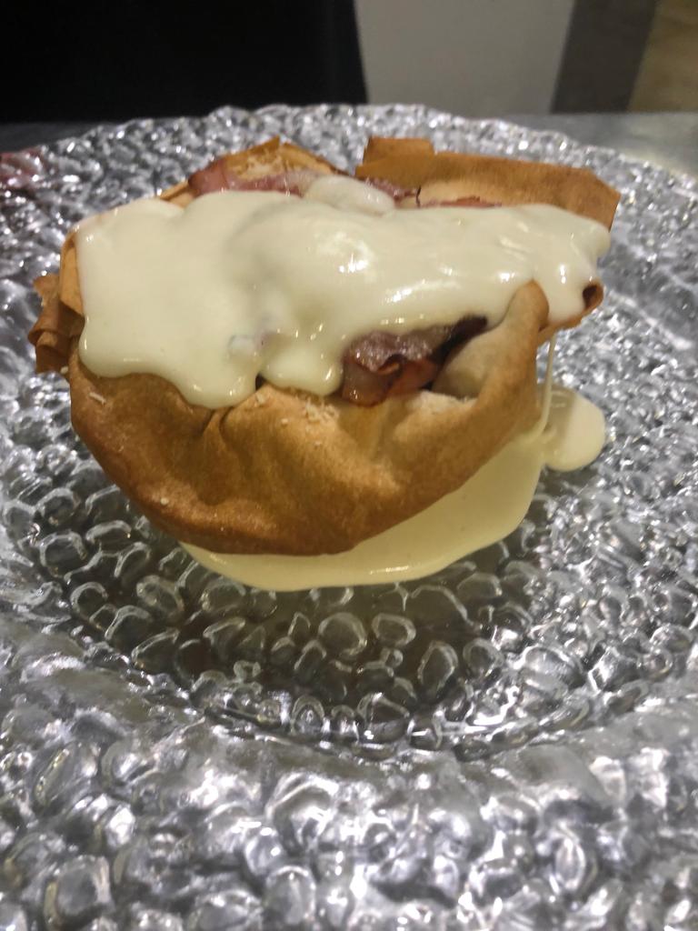 Pasticcino da dessert ricoperto di glassa bianca su un piatto ricoperto di carta stagnola.