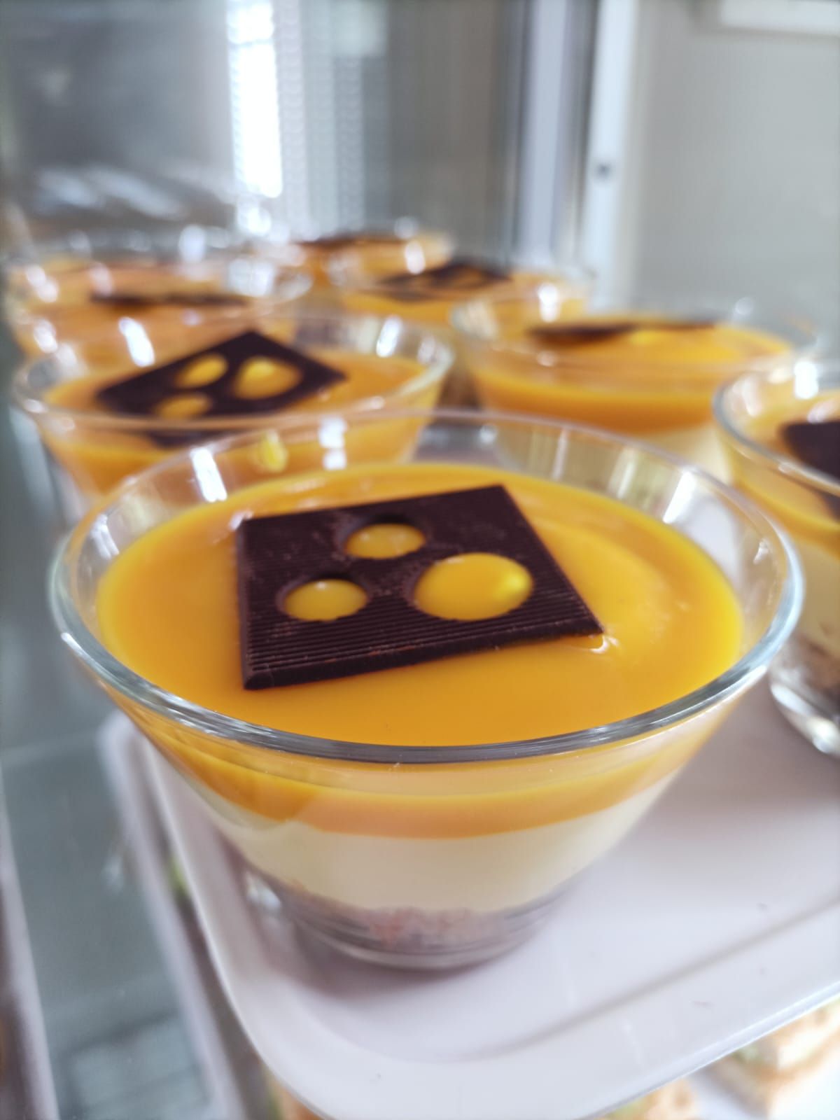 Coppette da dessert con guarnizione all'arancia e decorazione al cioccolato su un vassoio