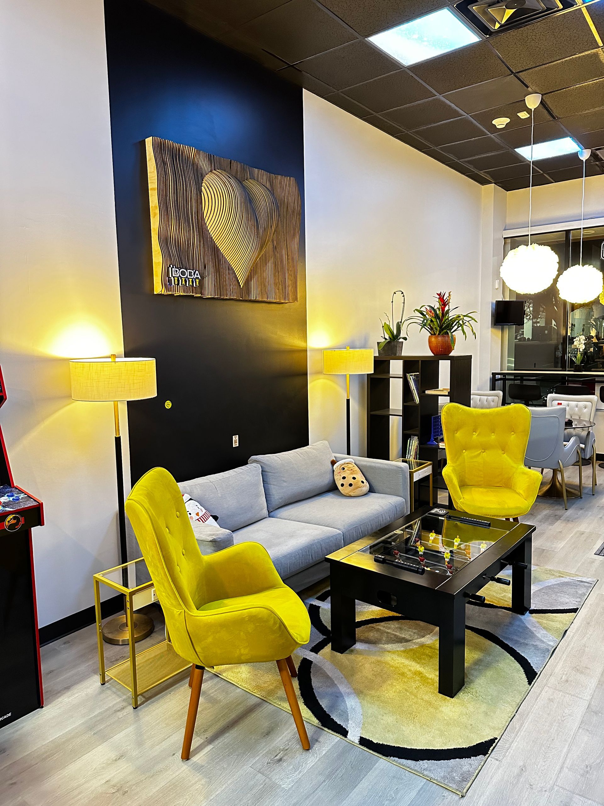 A living room with a couch , chairs , a coffee table and a painting on the wall.