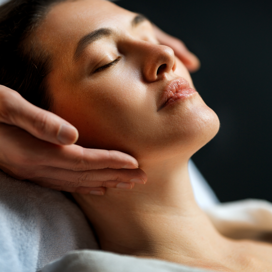 Woman receiving a facial massage with eyes closed in a spa setting