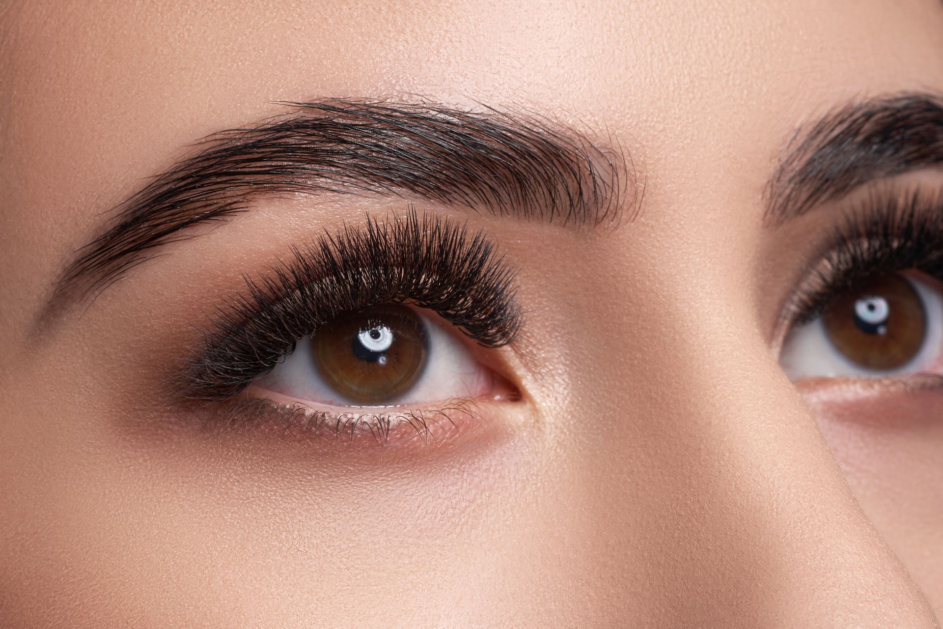 Close-up of a person’s eyes with dark smoky eye makeup and shaped eyebrows