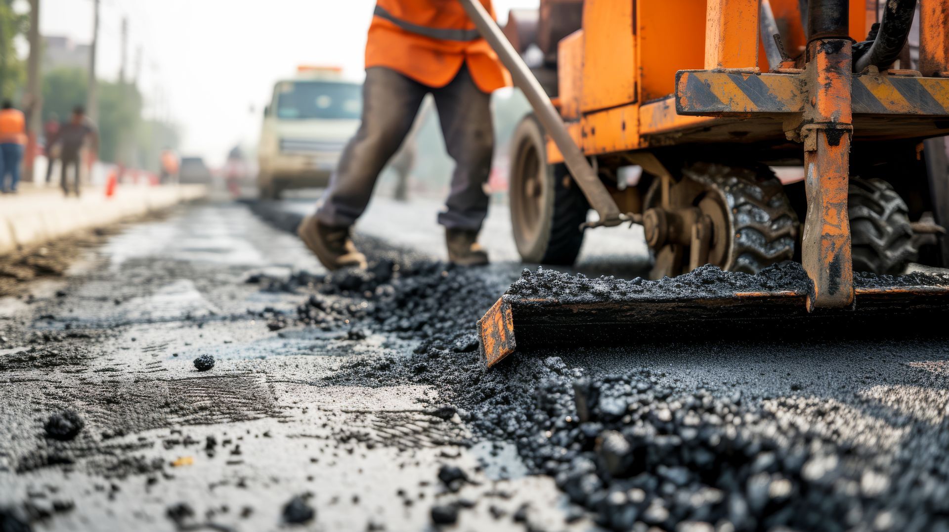 Worker performing asphalt repaving on a road construction site, ensuring a smooth, durable surface.