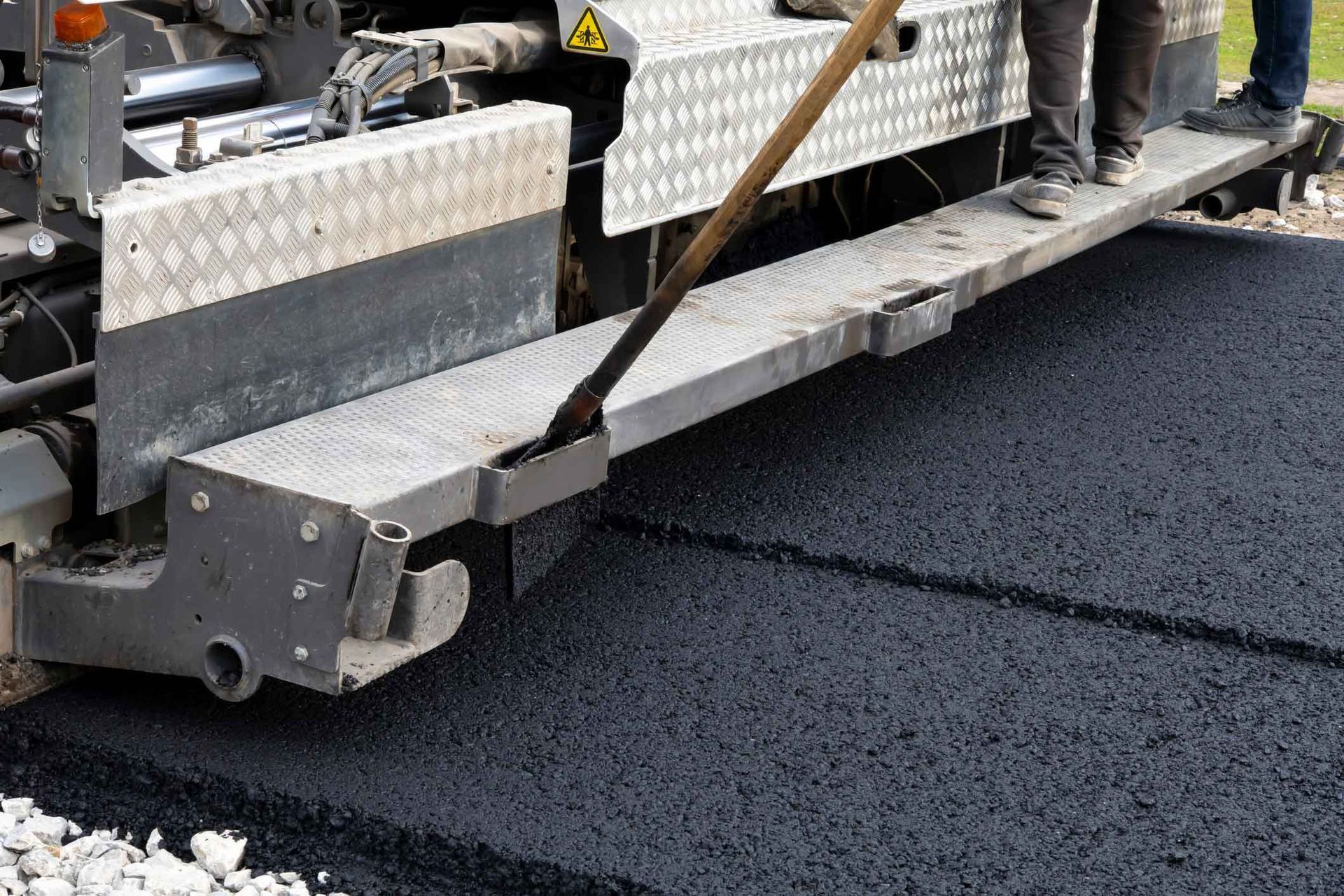 Road paving machine laying asphalt with workers on the platform. Road paving machine laying asphalt with workers on the platform.