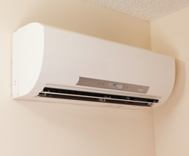 HVAC refrigerant lines and gauges connected to a wall unit during service