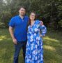 A man and a pregnant woman are posing for a picture
